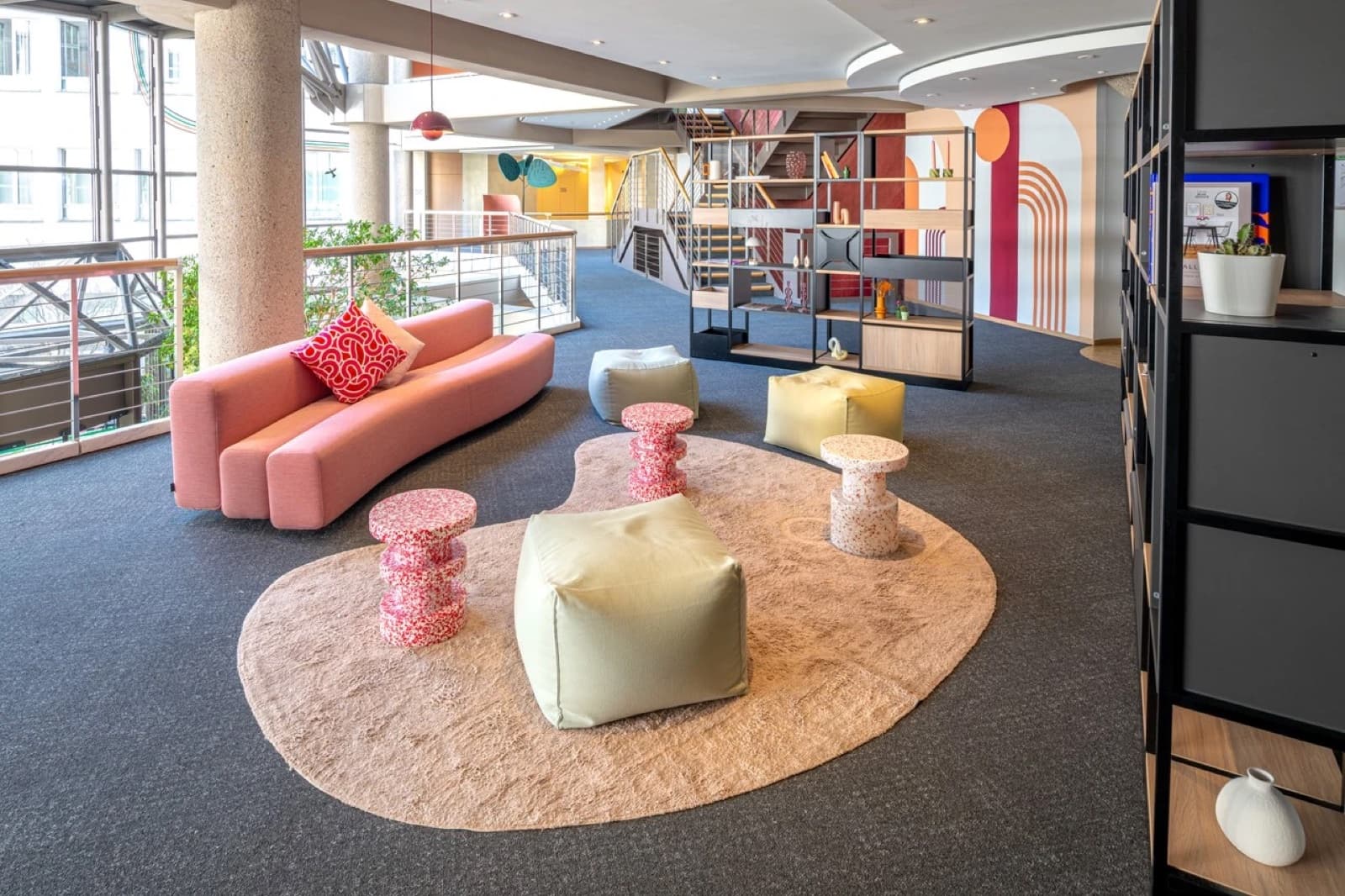 Lounge im Videostudio Mannheim – Sitzbereich mit Sofa, Poufs und Atrium